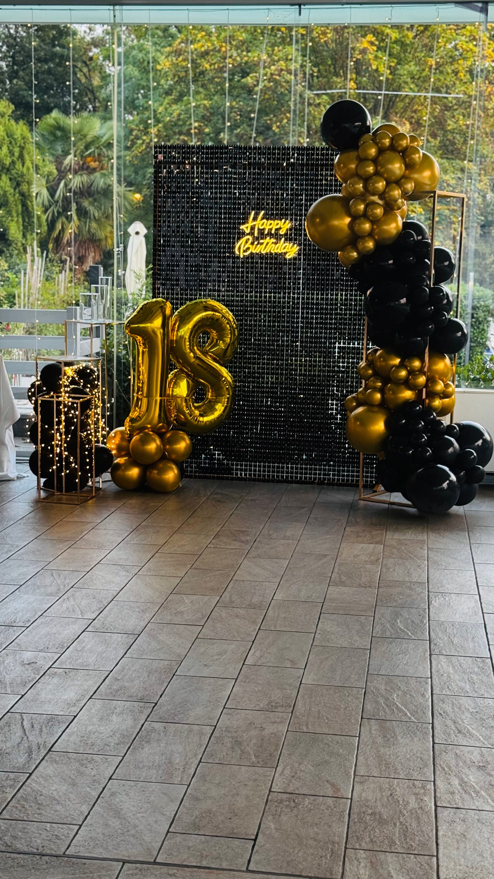 18esimo compleanno con palloncini neri e oro, parete paillettes nera e numeri foil 18 dorati