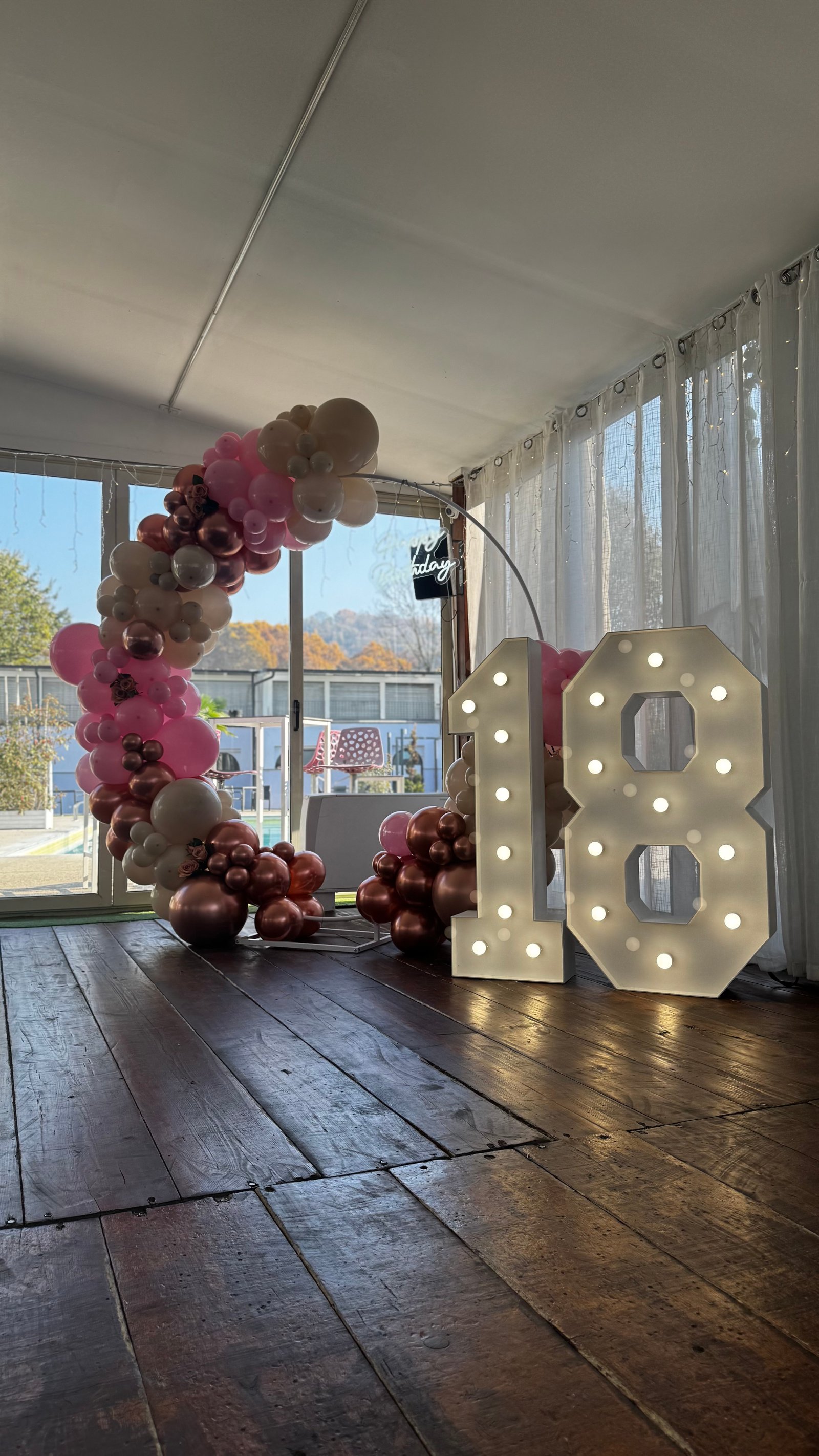 18esimo compleanno con arco palloncini rosa, bianchi e rose gold con numeri luminosi 18